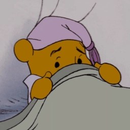 Winnie the Pooh en la cama cubriéndose con una manta