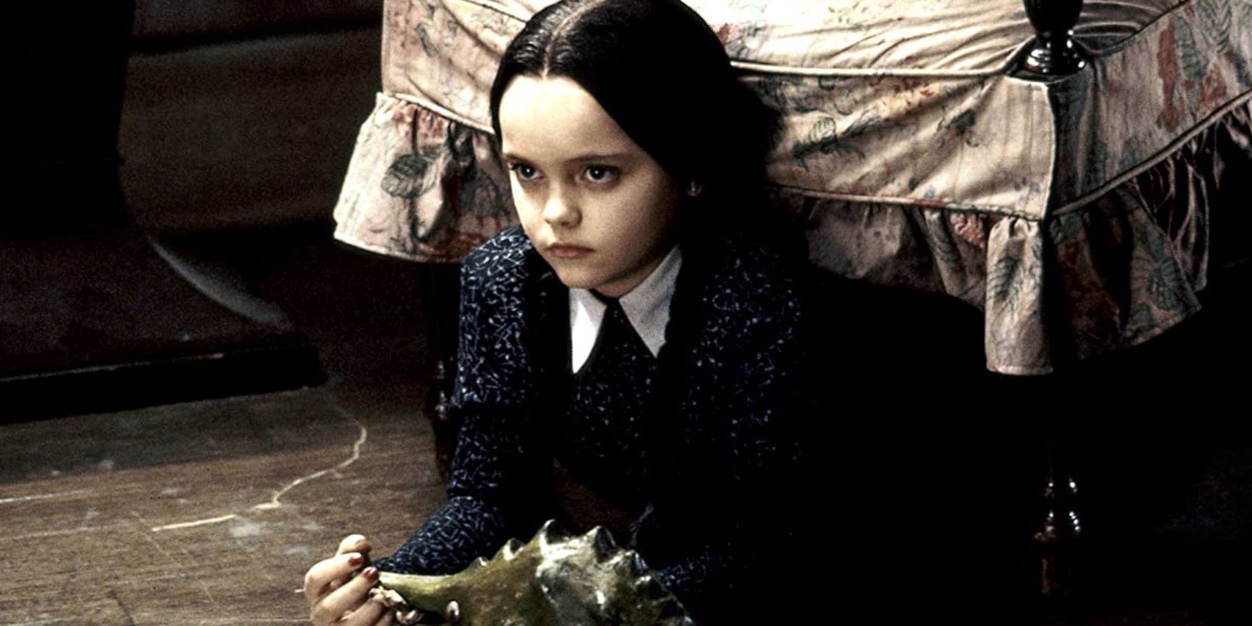 Christina Ricci como Wednesday Addams con un dinosaurio de juguete en la película 'La familia Addams'