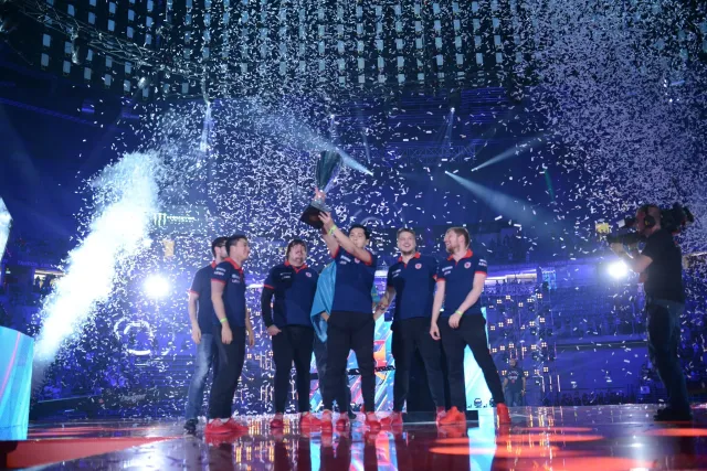HObbit de Gambit sosteniendo el trofeo PGL Major Krakow rodeado de sus compañeros de equipo mientras cae confeti en el escenario.